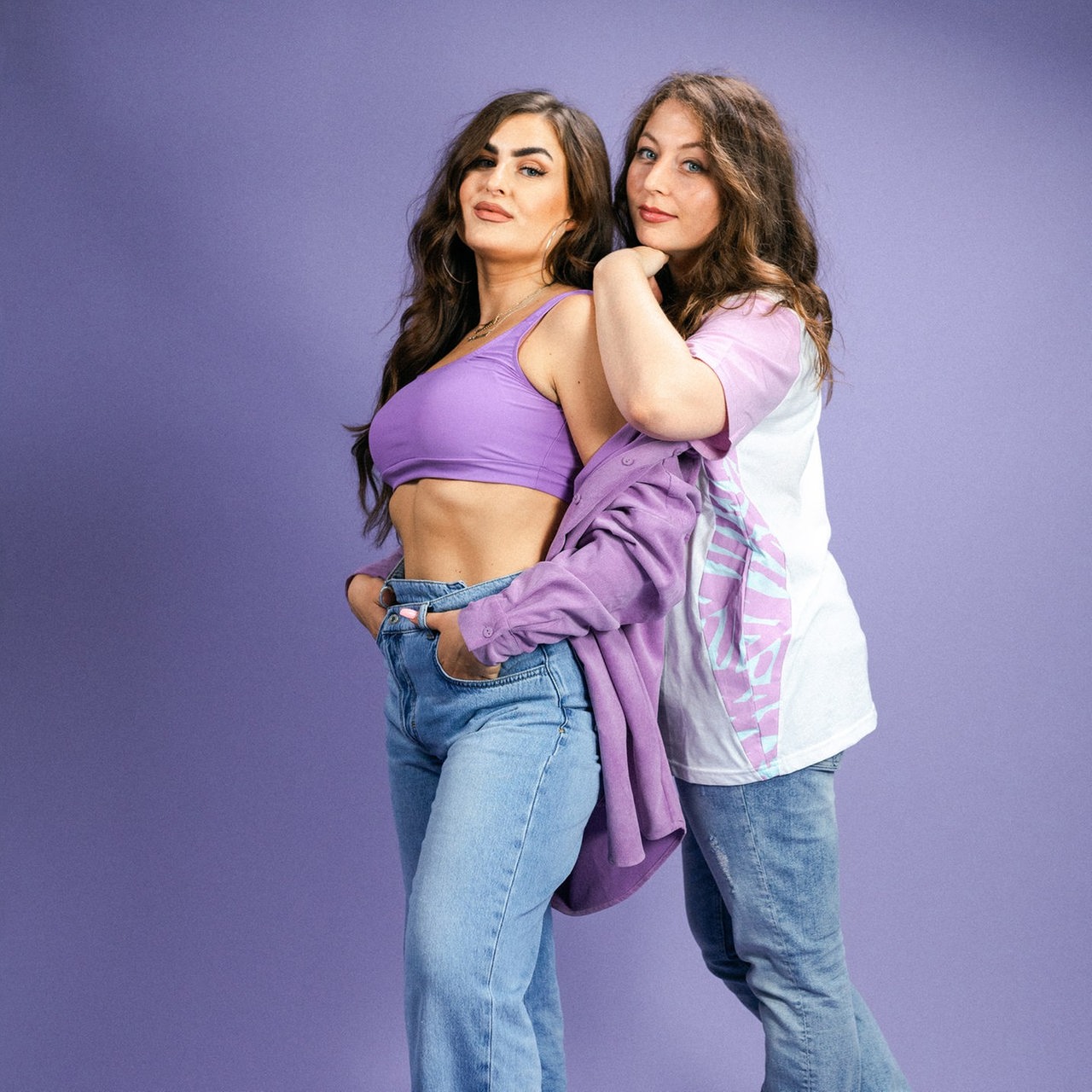 Karina und Larissa stehen vor einem violetten Hintergrund.